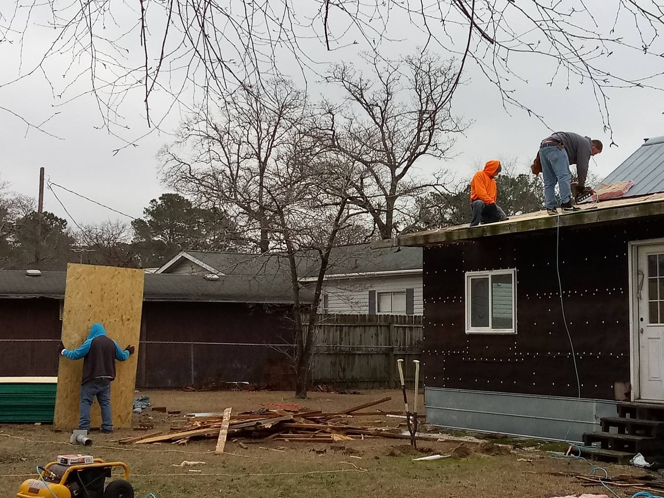 Roofing crew installing new roof decking on a home